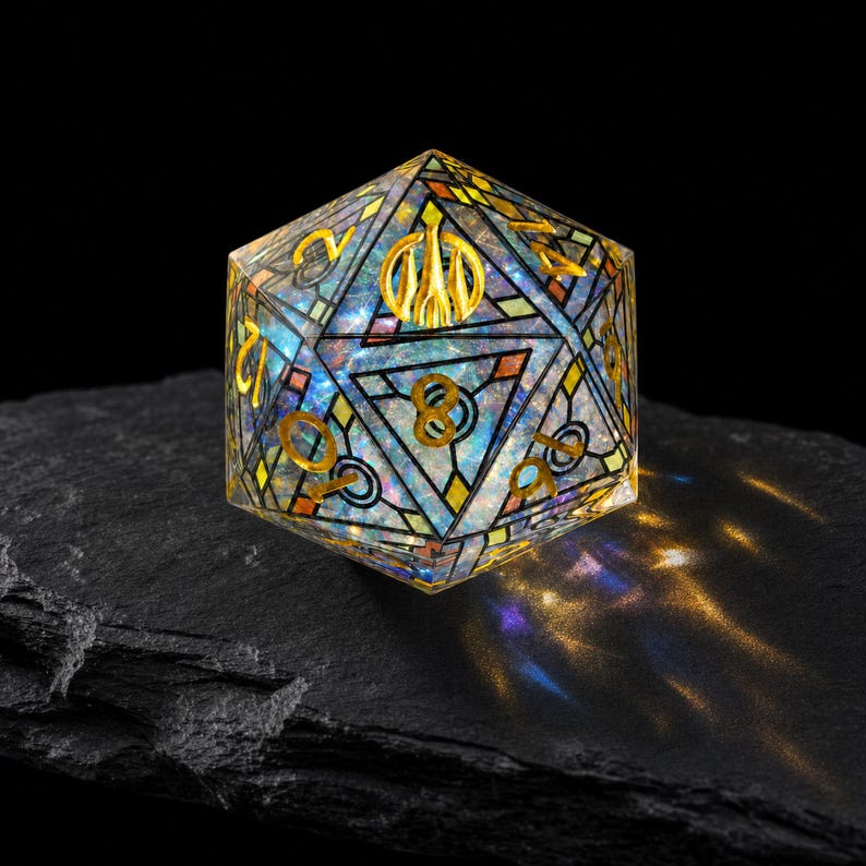 May include: A twenty-sided die featuring a stained-glass inspired design with a translucent, iridescent core. The surface is divided by black lines into geometric shapes, with gold-colored numbers and a gold symbol at the top vertex.