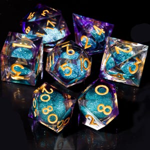 May include: Set of seven polyhedral dice with a clear, iridescent exterior and teal glitter interiors. The numbers are gold. The dice are for tabletop games like Dungeons and Dragons. The dice are displayed on a black surface.
