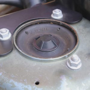 May include: A white ceramic mug with a black handle and the text "But First, Coffee" in a bold, black font. The mug is set against a neutral background, highlighting its simple design.