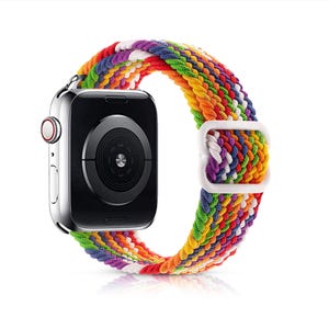 May include: A colorful braided Apple Watch band with a white buckle. The band is made of woven threads in shades of red, orange, yellow, green, blue, and purple.