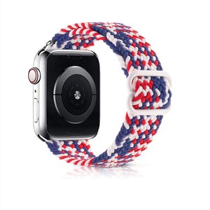 May include: A red, white, and blue braided Apple Watch band. The band is made of woven nylon and has a white buckle.
