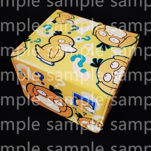 May include: A yellow, square tissue box featuring cartoon Psyduck characters and blue question marks. The tissue box has a repeating pattern of Psyduck and question marks.
