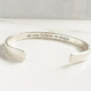 Puede incluir: Pulsera de plata con acabado martillado. El interior de la pulsera est&aacute; grabado con el texto "do you believe in magic".