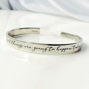 May include: Silver bangle bracelet with the inscription "Good things are going to happen today".