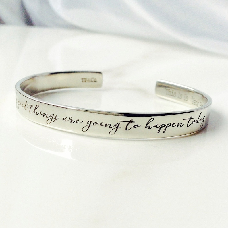 May include: Silver bangle bracelet with the inscription "Good things are going to happen today".