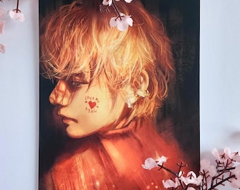 May include: A portrait print featuring a person with orange hair and a red top. The person's face is turned to the side, with the words "Love Me Again" and a heart tattoo on their cheek. Pink flowers frame the print.