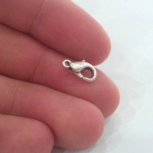 May include: Silver-toned lobster clasp for jewelry making. The clasp is small and has a shiny finish.