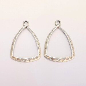 Puede incluir: Dos blanks de pendientes de plata en forma de tri&aacute;ngulo con textura martillada. Los blanks tienen un bucle en la parte superior para sujetar los hilos de los pendientes.