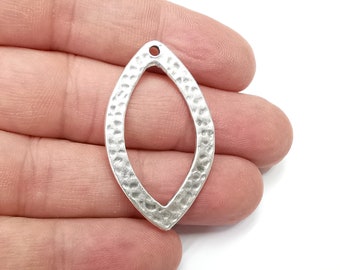 May include: Silver-toned metal pendant with a hammered texture and a teardrop shape. The pendant has a hole at the top for attaching a chain or cord.