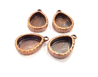 May include: Four copper-colored pendant settings in a teardrop shape. Each setting has a smooth, rounded edge and a textured surface.