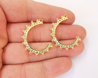 May include: Two gold-toned hoop earrings with a decorative beaded edge.