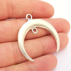 Puede incluir: Encanto de luna creciente de plata con dos anillos de salto para sujetar a joyas u otras manualidades.