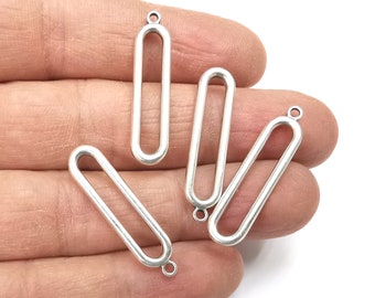 May include: Four silver-toned metal oval-shaped pendant charms with a jump ring at the top. The charms are open on the sides.