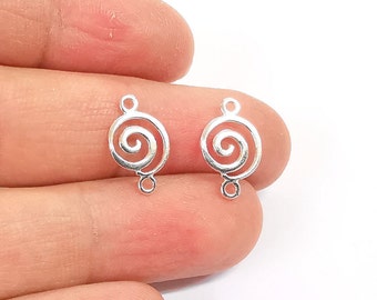May include: Two silver-toned metal pendant charms with a spiral design. Each charm has two jump rings for attaching to jewelry.