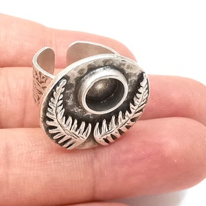 Op de afbeelding: Zilveren ring met een varendesigne en een ronde bezel voor een cabochonsteen. De ring is verstelbaar en heeft een gehamerde textuur.