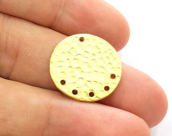 May include: Gold-toned round metal charm with a hammered texture and six holes around the edge.