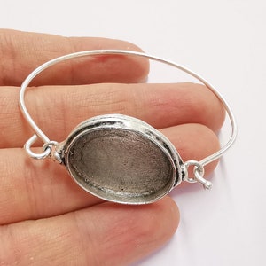 Op de afbeelding: Zilveren armband met een ronde, zilverkleurige bezel voor een cameo of andere versiering.