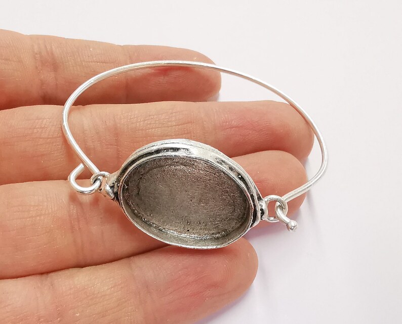 Op de afbeelding: Zilveren armband met een ronde, zilverkleurige bezel voor een cameo of andere versiering.