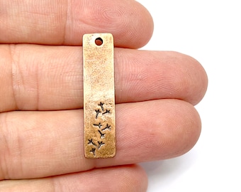 May include: A rectangular metal charm with a distressed finish and a small hole at the top. The charm features a design of small birds flying in a row.