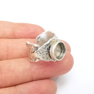 Puede incluir: Anillo de plata con un diseño texturizado y un engaste redondo para un cabujón.