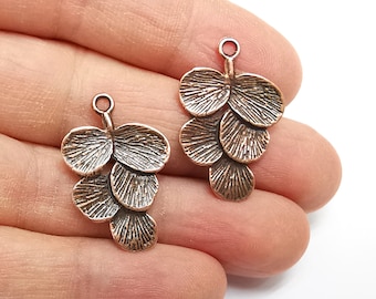 May include: Two copper-colored metal charms shaped like clusters of leaves. Each charm has five leaves, with a loop at the top for attaching to jewelry or other crafts.