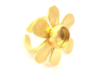 May include: A gold-toned ring shaped like a flower with five petals. The ring is open on one side and has a smooth, rounded center.