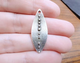 May include: A silver pendant in the shape of a leaf with a row of small silver dots down the center.
