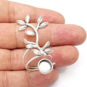 May include: Silver ring with a leafy branch design and a round bezel for a cameo or cabochon.