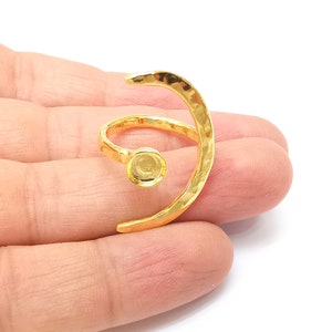 Op de afbeelding: Gouden ring met een gehamerde afwerking en een ronde bezel-setting. De ring is open en kan worden aangepast aan verschillende vingermaten.