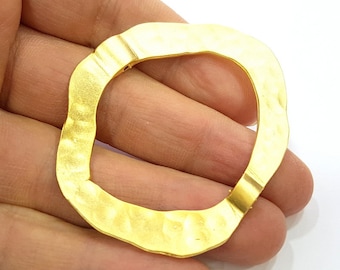 May include: A gold-toned metal ring with a hammered texture and an irregular, wavy shape.