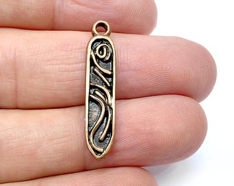 May include: A copper-colored pendant with an intricate design of swirling lines and a small circle in the center. The pendant is rectangular in shape and has a loop at the top for attaching a chain.