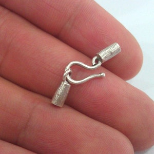 May include: Silver clasp with two barrel end caps. The clasp is designed to be used for jewelry making.