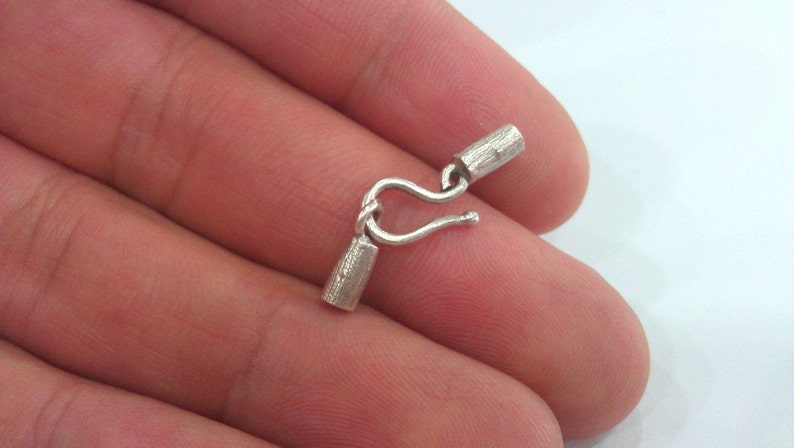 May include: Silver clasp with two barrel end caps. The clasp is designed to be used for jewelry making.
