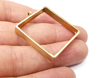 May include: Gold square pendant with a loop at the top for hanging. The pendant is made of metal and has a smooth, polished finish.
