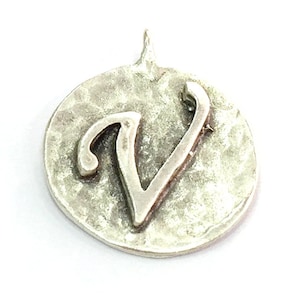 May include: Silver charm with a hammered finish and the letter V in a cursive font.