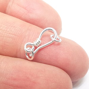 May include: Silver-toned metal clasp with a loop and a twisted wire design. The clasp is designed for jewellery making.