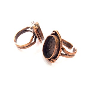 May include: Two copper adjustable rings with oval-shaped settings for adding a stone or cabochon.