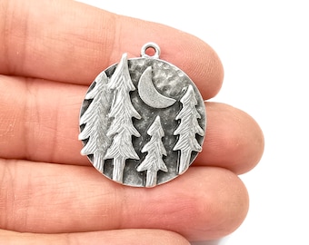 May include: Silver charm with a textured background featuring a crescent moon and five stylised pine trees.