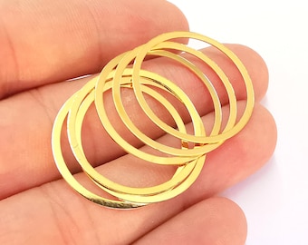 May include: Four gold-colored metal rings of different sizes, stacked on top of each other.