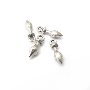 Może przedstawiać: Cztery srebrne zawieszki w kształcie łzy z ostrym zakończeniem. Każda zawieszka ma małą pętelkę u góry do przymocowania do naszyjnika lub bransoletki.