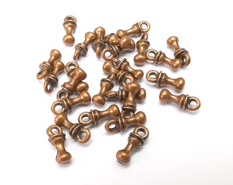 May include: A group of 20 antique gold-toned metal charms in the shape of a small, round, decorative knob with a loop at the top. The charms are scattered on a white surface.