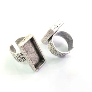 May include: Two silver rings with a rectangular bezel setting. The rings have a textured, hammered finish.