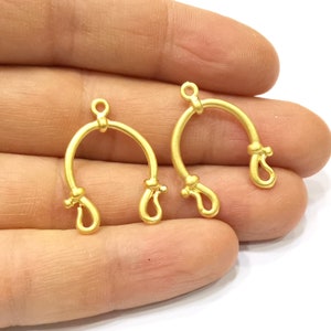 May include: Two gold-toned metal hoops with a knotted design. The hoops are open at the top and have a loop at the bottom.