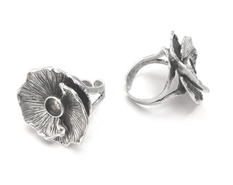 Puede incluir: Dos anillos de plata con un diseño de hongo. Los anillos son ajustables y tienen un acabado liso y pulido.