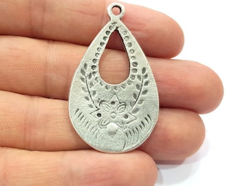 Puede incluir: Pendiente de plata en forma de lágrima con un diseño recortado y detalles florales. El pendiente tiene un bucle en la parte superior para sujetarlo a una cadena o cordón.