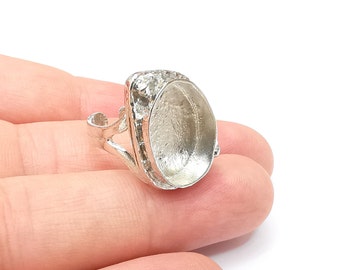 May include: Silver ring with an oval-shaped bezel setting. The ring is designed to hold a cabochon stone.