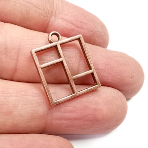 May include: A copper-coloured metal charm shaped like a window with four panes. The charm has a loop at the top for attaching to a necklace or bracelet.