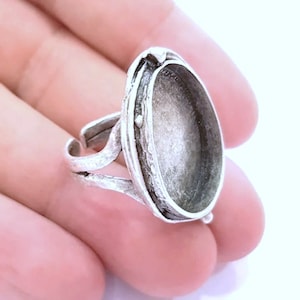 May include: Silver ring with an oval-shaped bezel setting. The bezel is open and ready to be filled with a cabochon stone or resin.