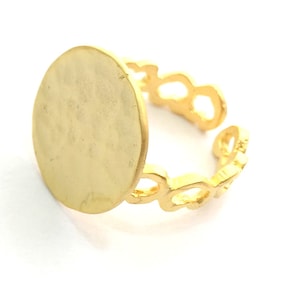 May include: Gold ring with a large, round, blank, flat surface. The ring band is made of a delicate, openwork design.