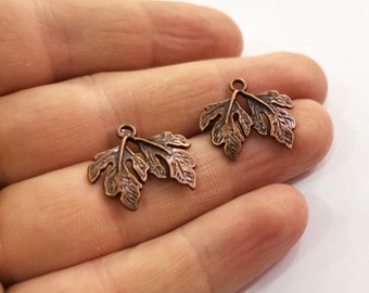 May include: Two copper-colored leaf charms with a hole at the top for attaching to jewelry or other crafts.